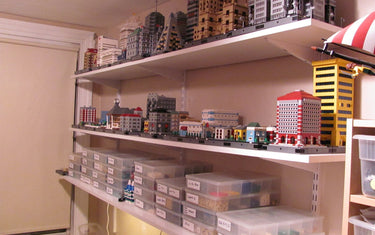 LEGO models and organized parts storage arranged around a building table in a compact hobby room