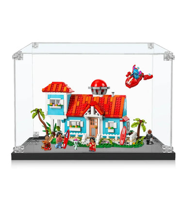 LEGO blue house with red roof, minifigures holding surfboards, palm trees, and flying spaceship in clear display case