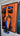 Orange and blue McLaren Formula 1 car model displayed in a frame on an orange background with circuit track outline