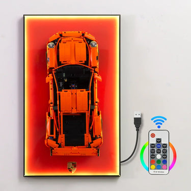 Orange LEGO Porsche car model mounted on a light-up display panel with USB and wireless remote control