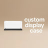Clear custom display case with black base on beige background and white text