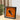 Framed LEGO Lamborghini model in orange displayed on a wooden table with blurred plant background