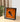 Framed LEGO Lamborghini model in orange displayed on a wooden table with blurred plant background