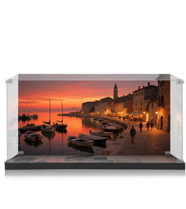 Sunset view of boats docked at a harbor with people walking along the waterfront in a historic coastal town