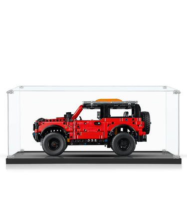Red LEGO Technic off-road vehicle model displayed in a clear acrylic display case