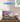 LEGO model of Sydney Opera House displayed in clear case on wooden table with sunset backdrop