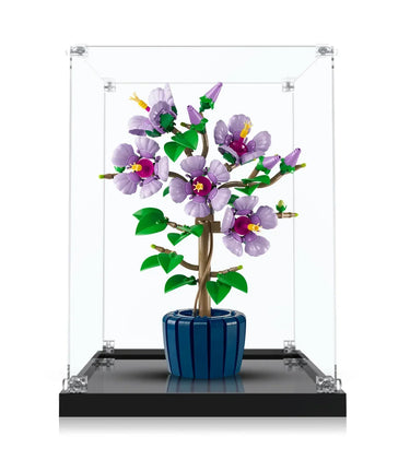 Purple LEGO flower bonsai in blue pot displayed inside clear glass case on black base