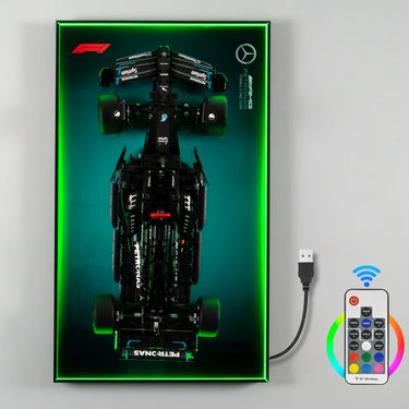 LEGO Mercedes AMG Petronas Formula One car model displayed on illuminated green light panel with remote control