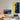 Modern minimalist workspace with desktop computer, racing car LEGO art on wall, desk lamp, and smart speaker