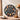 Black round clock with colorful cartoon character figurines at each hour, on a checkered tablecloth with cups and vase