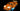 Orange LEGO sports car model with headlights, roof lights, decals, and underglow lighting on black background