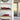 Red scale model racing cars displayed in clear acrylic cases on wooden shelves in a modern home setting
