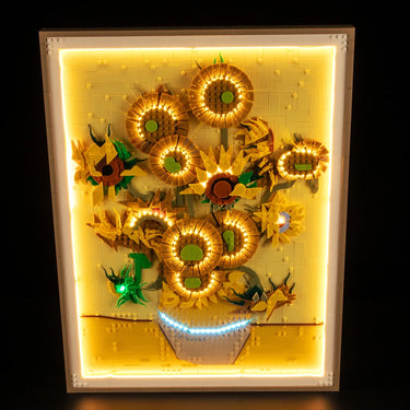 Illuminated LEGO artwork of sunflowers in a vase with warm yellow and green tones