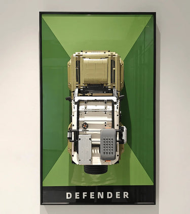 Top-down view of Lego Land Rover Defender model mounted on green and black framed display