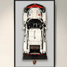 Framed top view of a white and red LEGO Porsche car model with Porsche logo below
