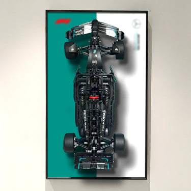 Top view of a black Mercedes AMG Petronas Formula 1 car model on teal and white background in black frame