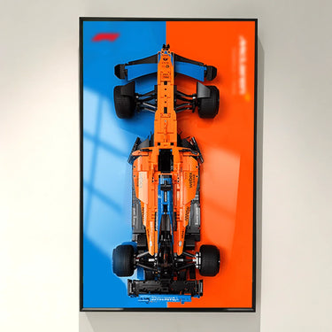 Top view of orange and blue LEGO McLaren Formula 1 car model mounted on blue and orange background