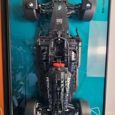 Top-down view of LEGO Mercedes AMG Petronas Formula 1 car model in a blue-framed display case