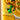 Close-up of a green LEGO scorpion with glowing eyes on a yellow LEGO baseplate with detailed brick patterns