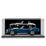 Blue classic convertible car model displayed in clear showcase with black backdrop and white car silhouette