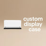 Clear custom display case with black base on beige background and white text