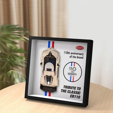 Framed tribute display featuring a model Bugatti EB110 car and 110th anniversary text on a wooden table