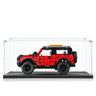 Red LEGO Technic off-road vehicle model displayed in a clear acrylic display case
