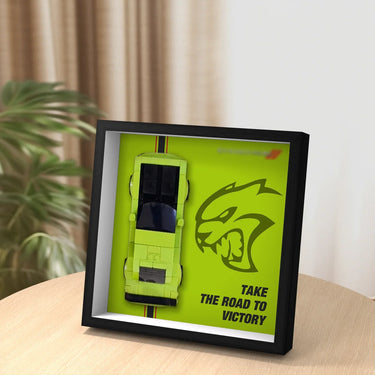 Framed display of lime green sports car model and fierce animal logo with text 'Take the road to victory'
