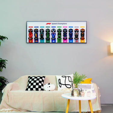 Modern living room with framed F1 Speed Champions race car models above beige sofa with patterned cushions