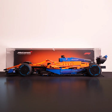 Lego McLaren Formula 1 race car model with orange and blue design on black surface