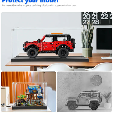 Red LEGO model car in a clear dustproof display case on a desk with plant and calendar