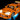 Orange LEGO sports car model with headlights, roof lights, decals, and underglow lighting on black background
