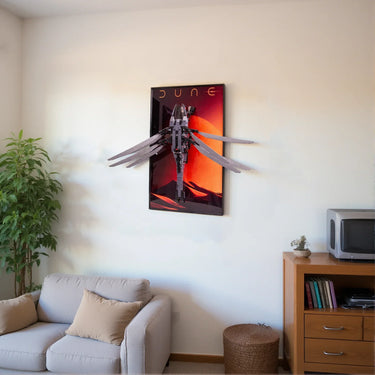 Modern living room with gray sofa, Dune wall art featuring flying mechanical bird sculpture, wooden cabinet, and potted plant