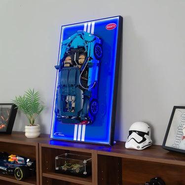 Blue Lego Bugatti Chiron model mounted on illuminated display board with white stripes on wooden shelf