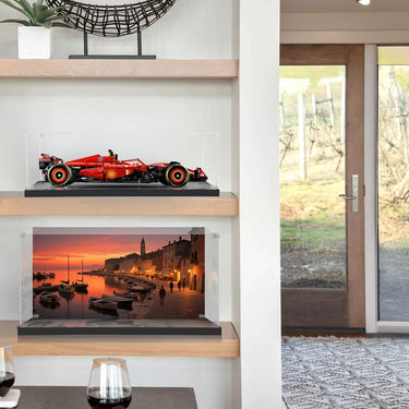 Modern living room shelves with red Formula 1 car model and sunset harbor photo inside glass cases